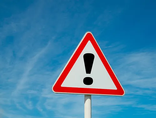 Triangular warning sign with red border and an exclamation point in the center.