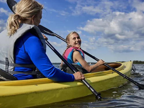 Two girls paddling in a yellow kayak 