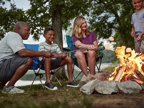 A group of people around a campfire at a campground.
