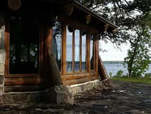 Stone and wood lodge with large windows, near a lake, at an Iowa state park