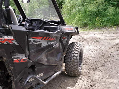 Close up of an off-highway vehicle parked on a dirt trail.
