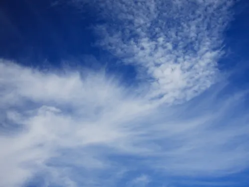 Wispy clouds on a dark blue sky.