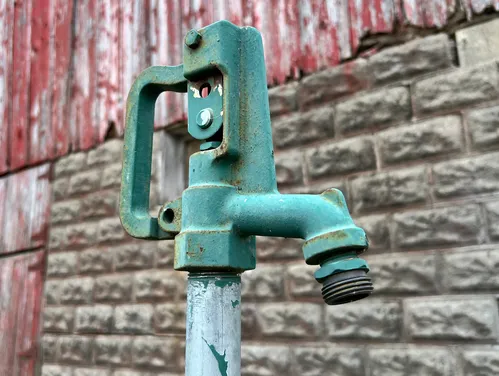 This image shows a rural well pump handle at a farm.