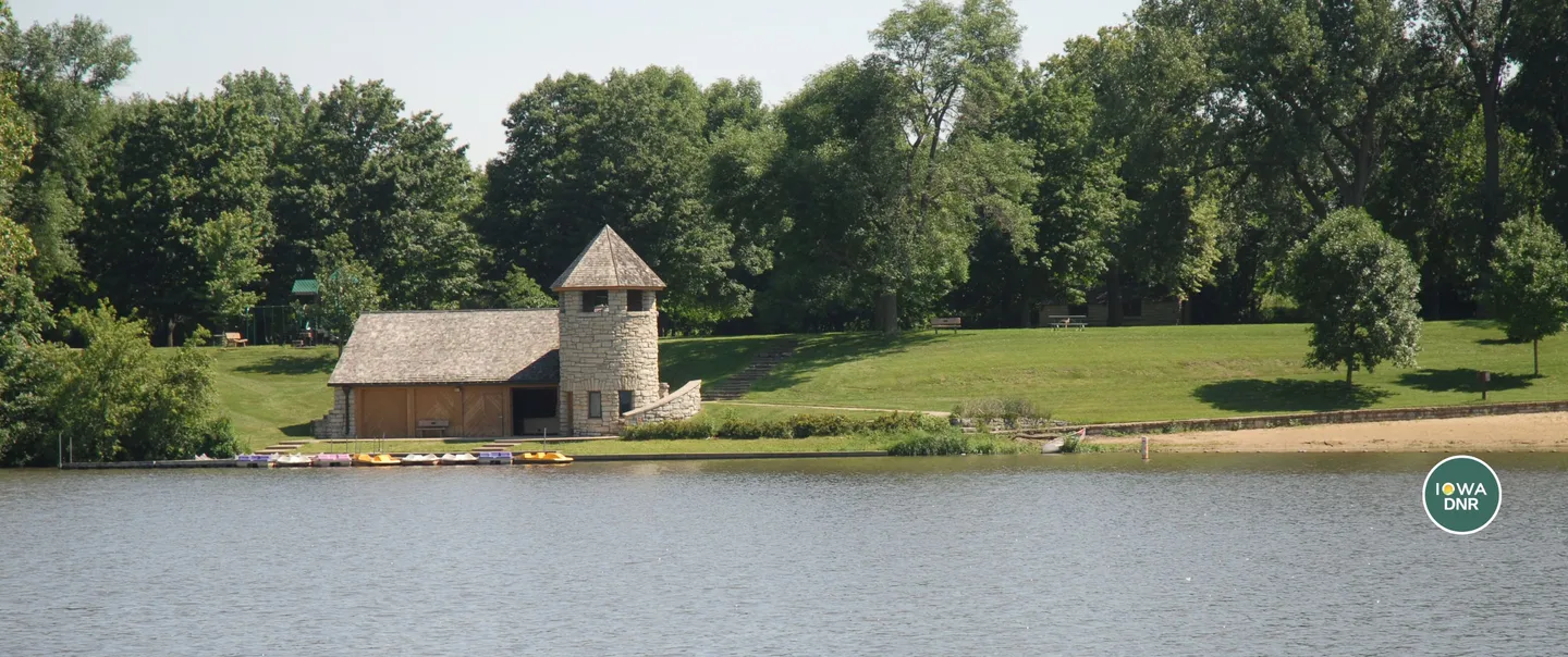 Backbone State Park's lodge with stone tower next to the lake with kayaks on the beach.