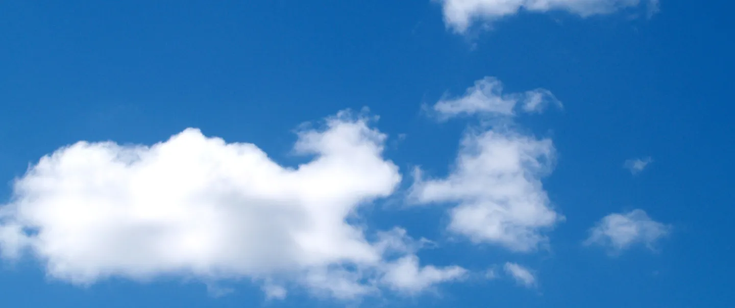 Dark blue sky with puffy clouds.