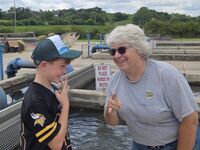 A young man visits with a hatchery staff member.