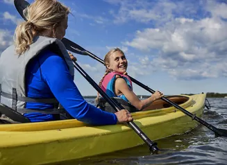 Two girls paddling in a yellow kayak 