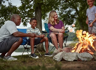 A group of people around a campfire at a campground.