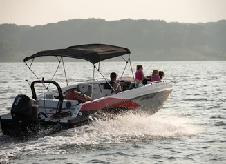 A family boats across a lake at the end of a summer day.