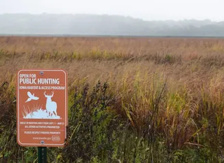 Orange Iowa habitat and access program sign in field.