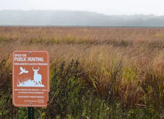 Orange Iowa habitat and access program sign in field.