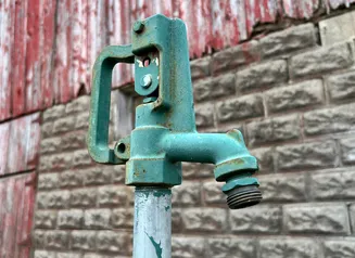 This image shows a rural well pump handle at a farm.