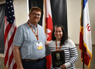 Iowa Department of Natural Resources Education, Outreach, and Marketing Section Supervisor, Megan Taube (right), is awarded the Midwest Association of Fish & Wildlife Agencies (MAFWA) Education Professional of the Year, by Iowa DNR’s Division Administrator Pete Hildreth, during the association’s meeting June 21-24, in Okoboji. 