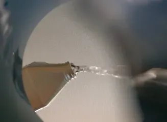 This image shows fluids being dumped down a drain from an unidentified container